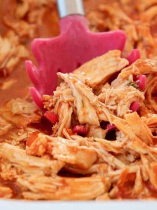 Shredded buffalo chicken with red serving spoon