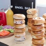Bagel bar setup with bagels on stands and bagel bar sign in background
