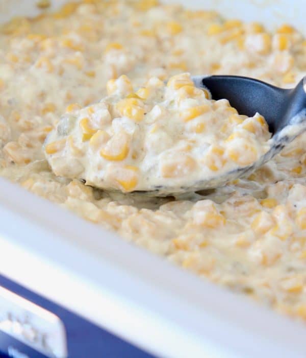 Creamed corn in crock pot with serving spoon