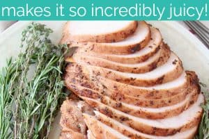 Sliced turkey breast meat on plate with fresh herbs