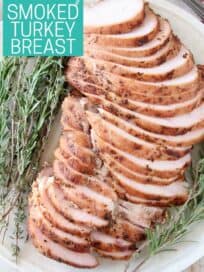 Sliced turkey breast on plate with fresh herbs