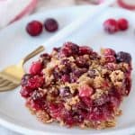Oatmeal Cranberry Bar on plate with fork and fresh cranberries