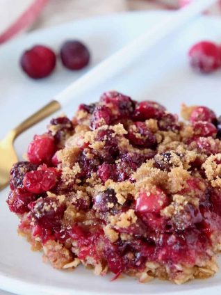 Oatmeal Cranberry Bar on plate with fork and fresh cranberries