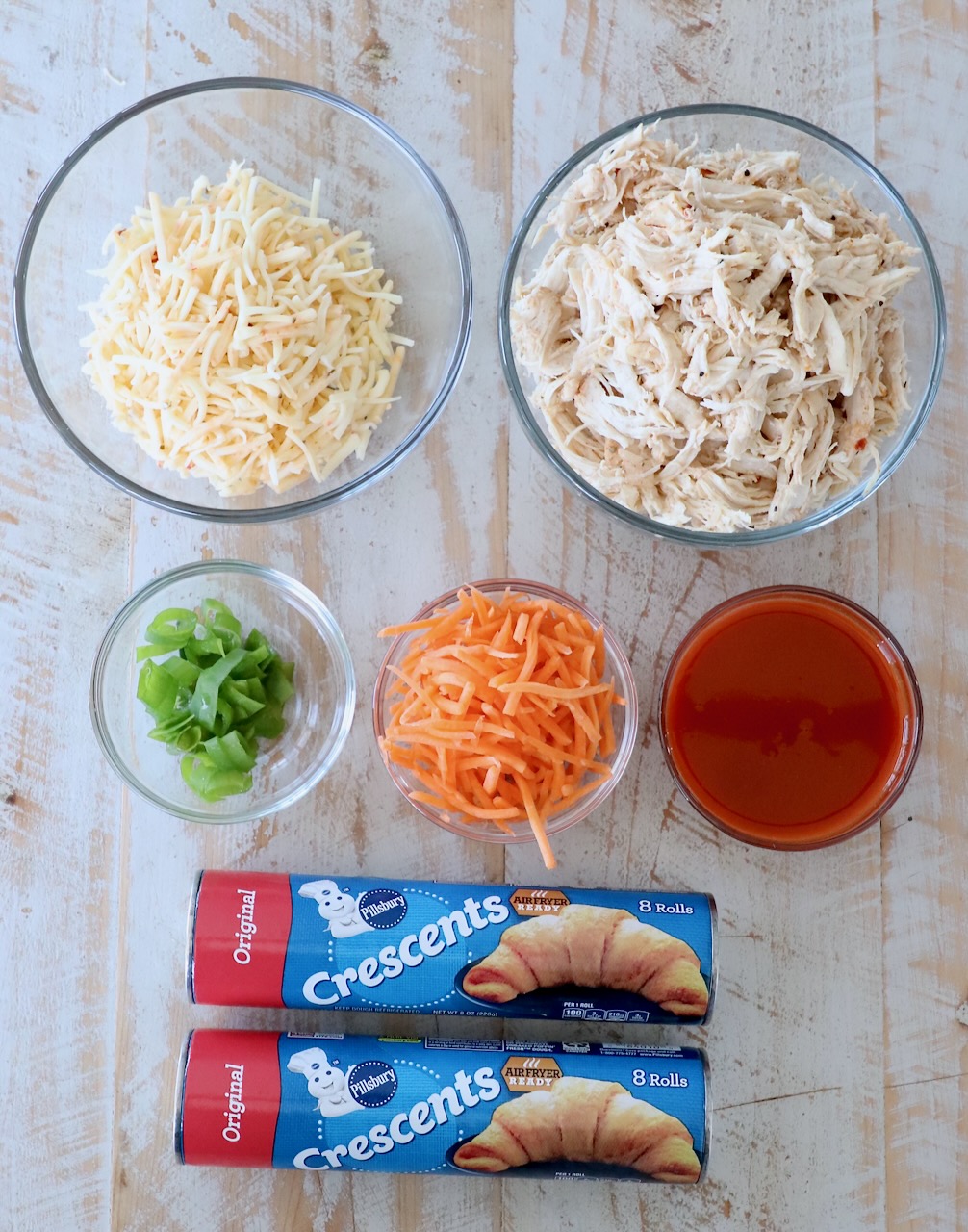 ingredients for buffalo chicken taco ring on white wood board