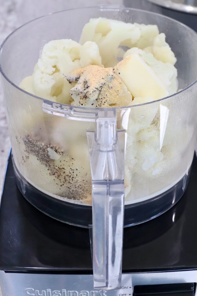 steamed cauliflower in a food processor with spices and butter