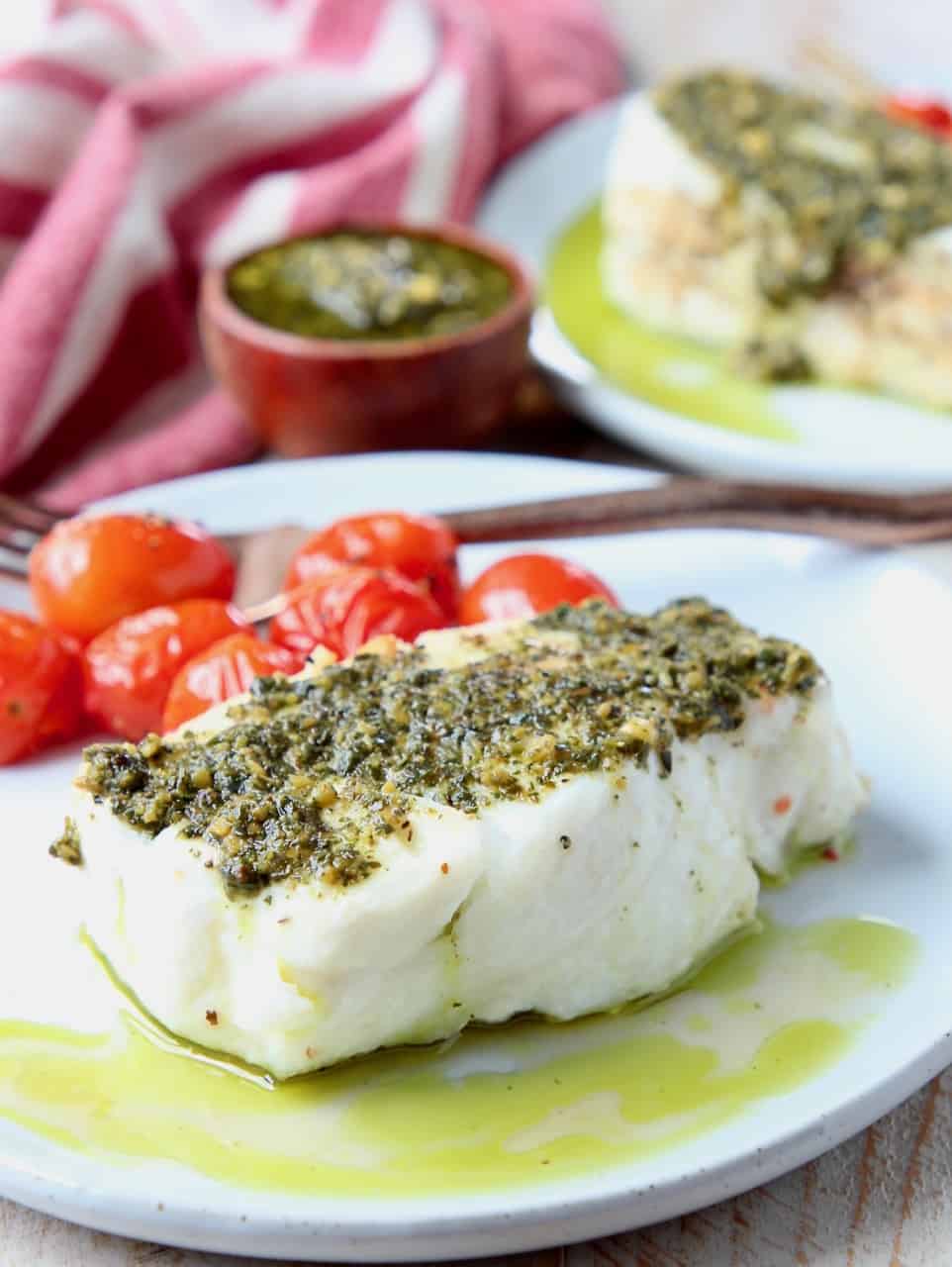 Chilean sea bass on plate topped with basil pesto