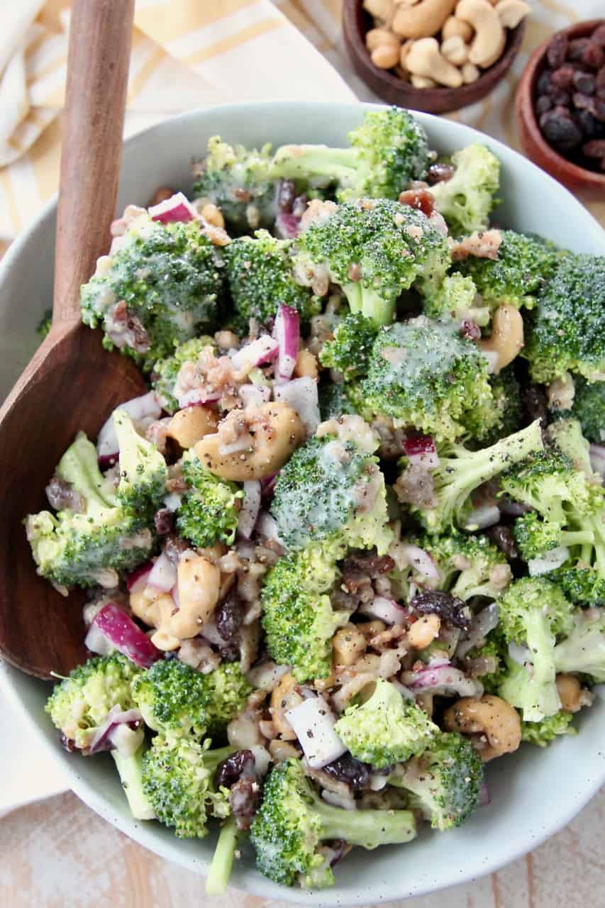 Broccoli salad in bowl with large wooden serving spoon