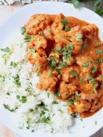 Cauliflower on plate, covered with Indian butter curry sauce