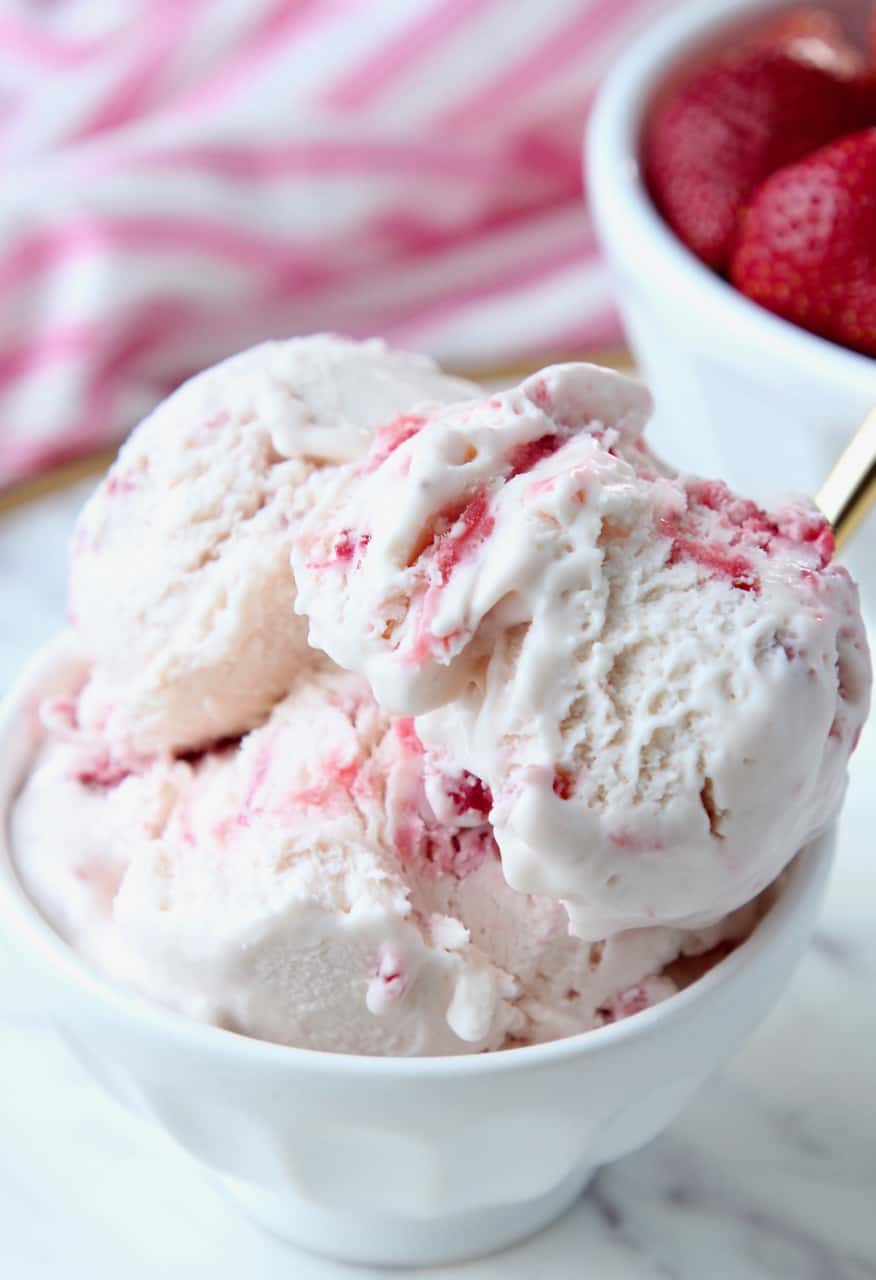 Scoops of strawberry ice cream in white bowl