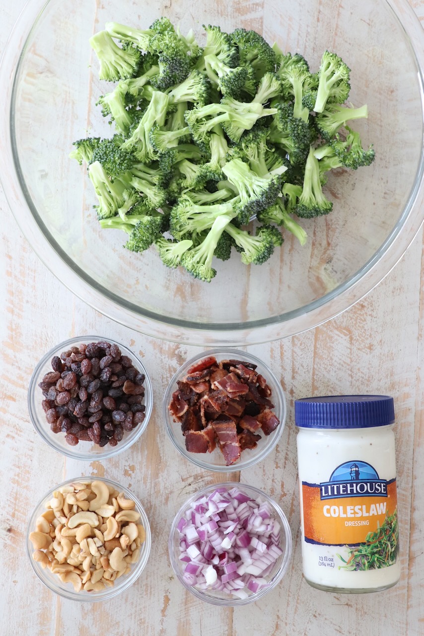 ingredients for broccoli salad on white wood board