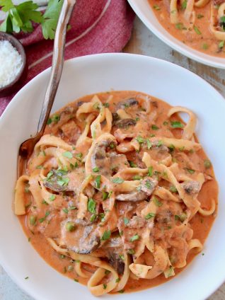 Overhead image of pasta in mushroom sauce in bowl with fork