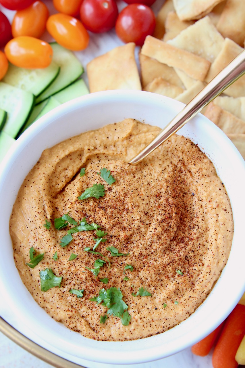 Sriracha hummus in bowl with gold spoon