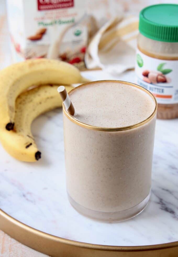 banana almond milk smoothie in glass with straw