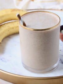 banana almond milk smoothie in glass with straw