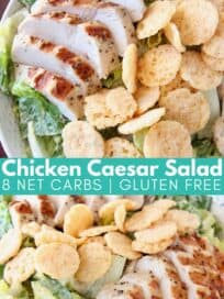 Sliced chicken on top of caesar salad