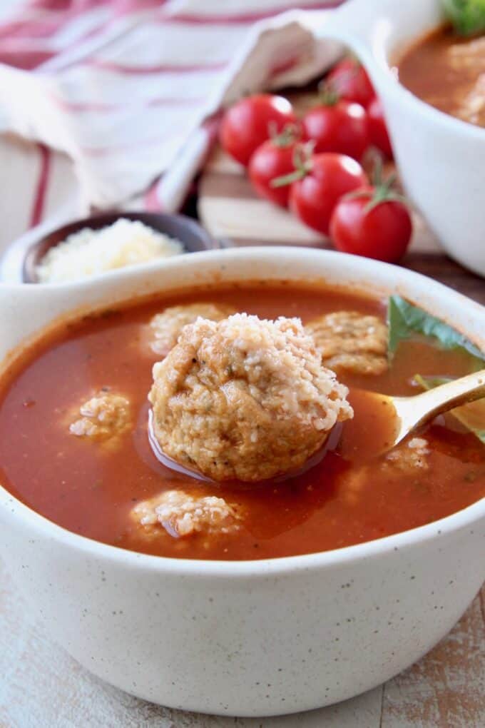 Meatball lifted out of bowl of soup with a spoon