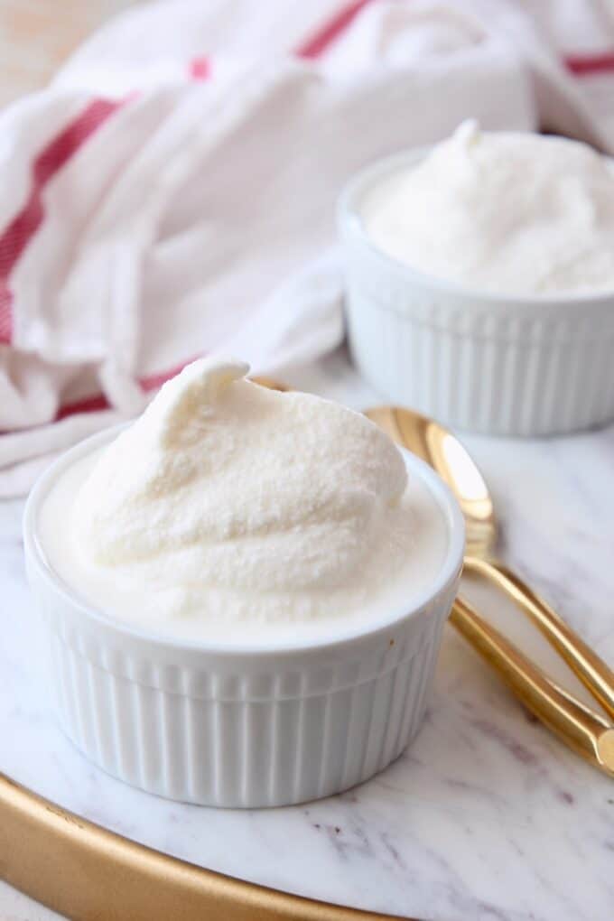 vanilla ice cream in white bowls with gold spoons