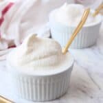 Vanilla ice cream in white ramekin with gold spoon