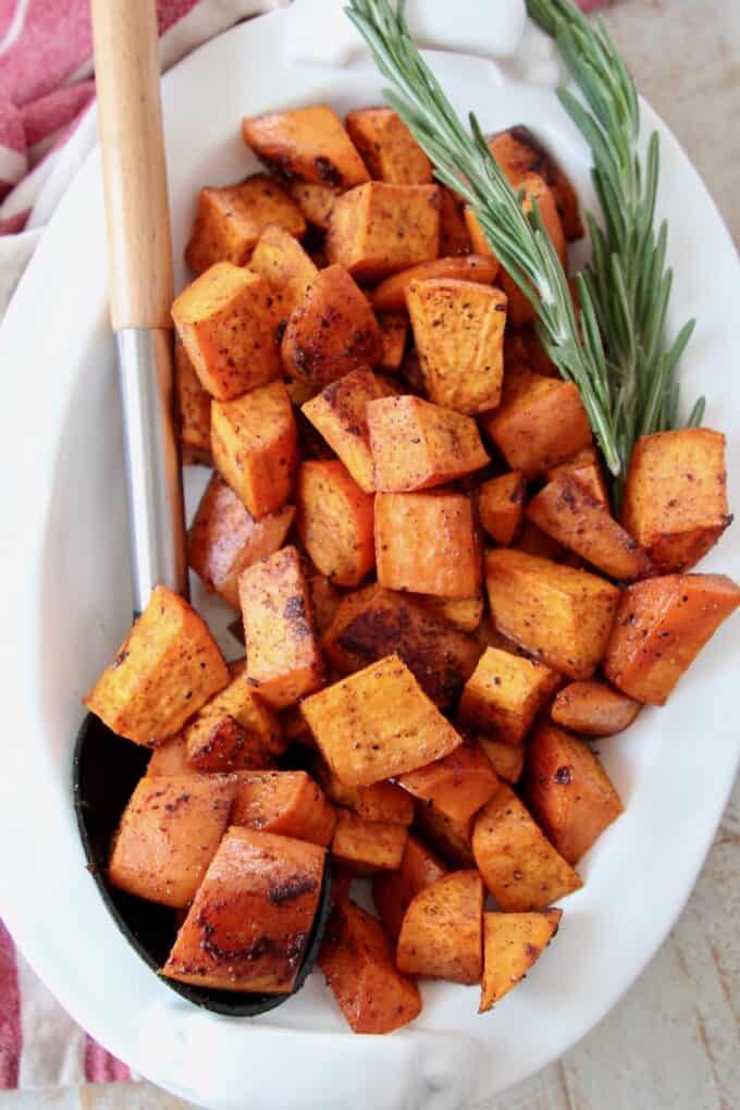 roasted cubed sweet potatoes in bowl with serving spoon