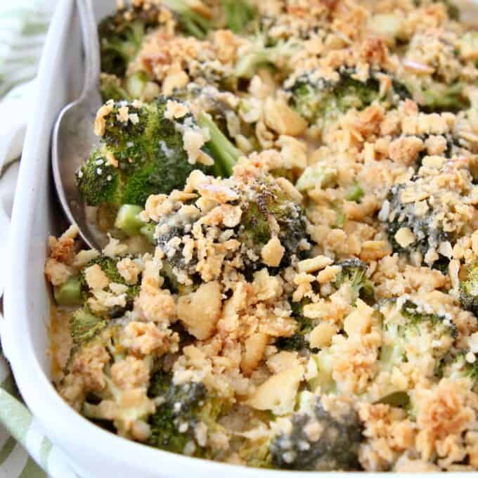 broccoli casserole with ritz cracker topping in dish with serving spoon