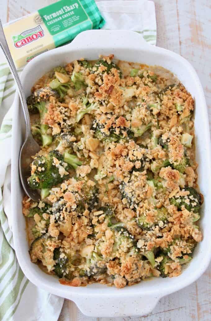 overhead image of broccoli casserole with ritz topping in casserole dish with serving spoon