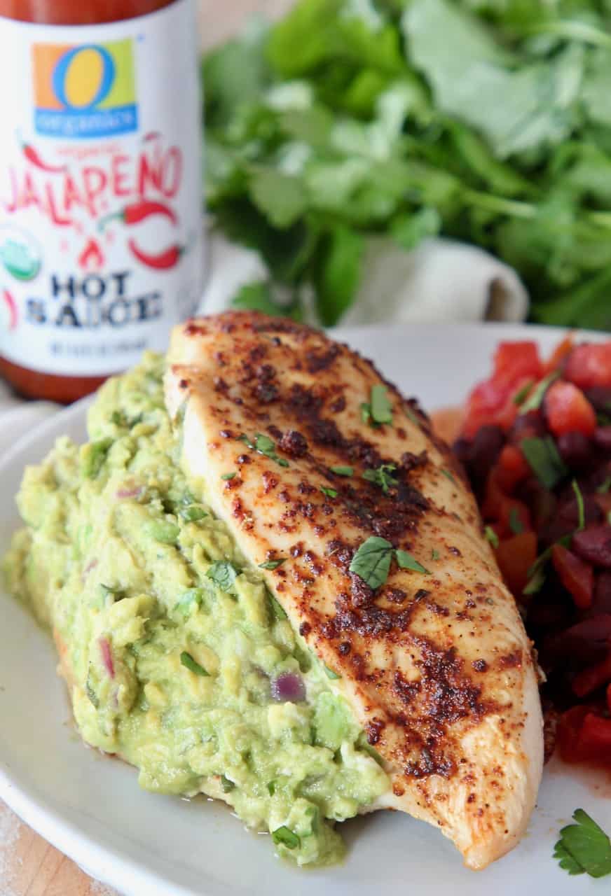 guacamole stuffed chicken breast on plate with black beans