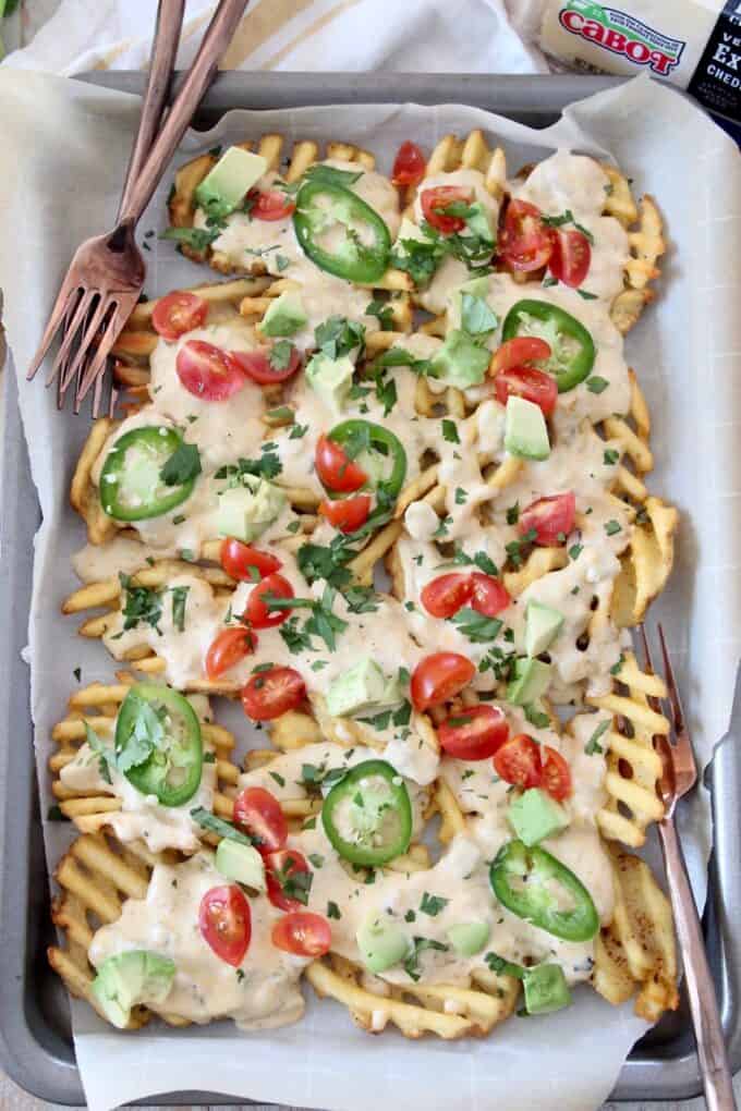 overhead image of waffle fry nachos on baking sheet with forks