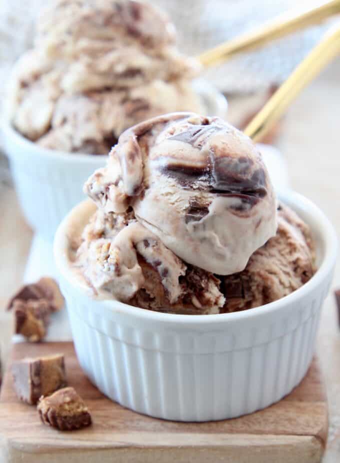 scoops of moose tracks ice cream in small white bowls with gold spoons