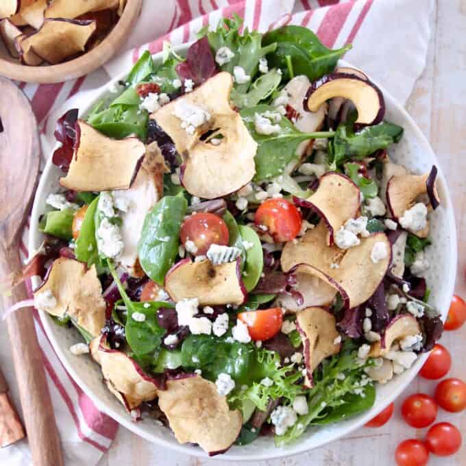 salad in bowl with apple chips and cherry tomatoes
