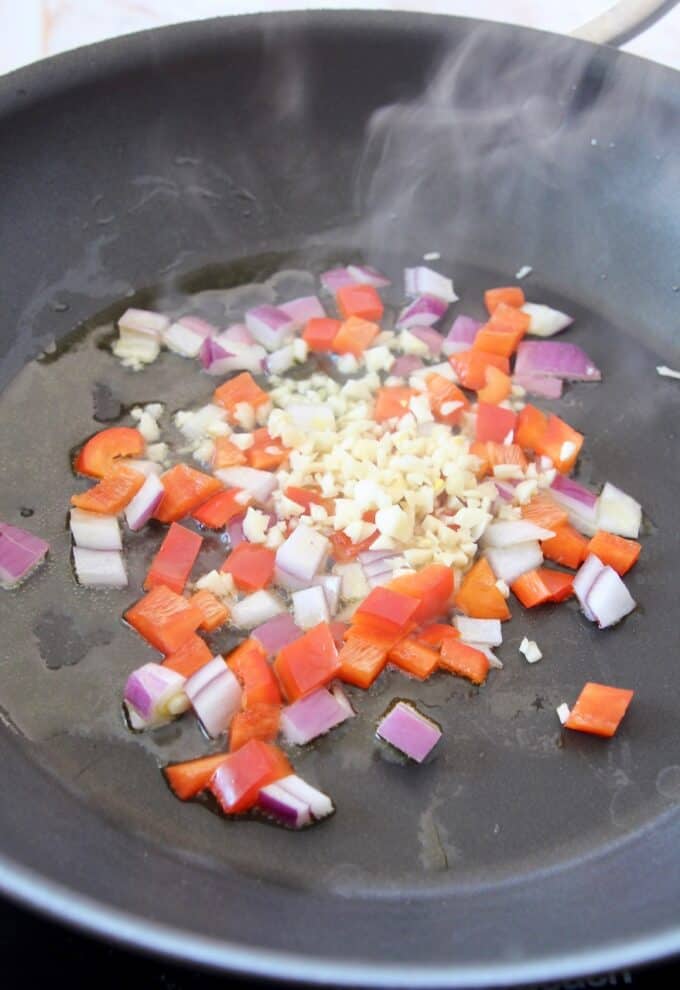 diced onion, pepper and garlic sautéing in skillet