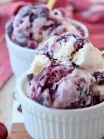 scoops of cherry ice cream in bowl with gold spoon