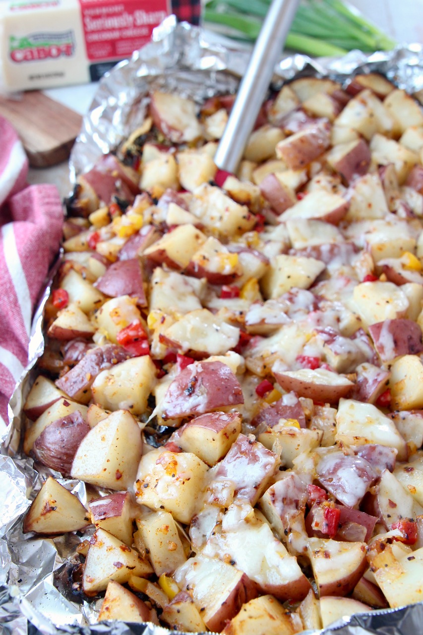 cheesy grilled cubed potatoes in foil with spatula