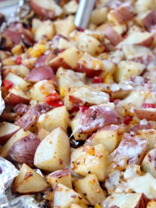 cheesy grilled cubed potatoes in foil with spatula