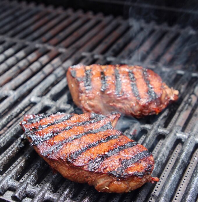 two sirloin steaks on grill