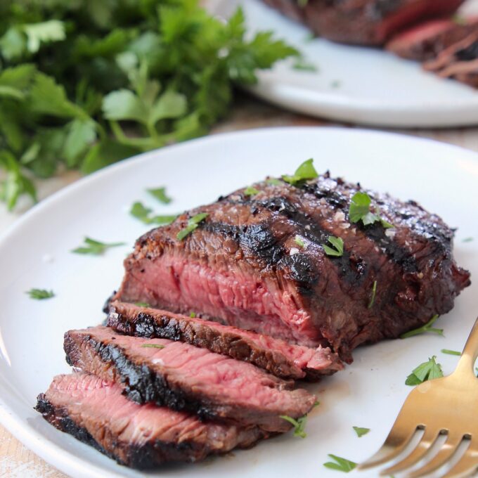 sliced grilled steak on plate with fork