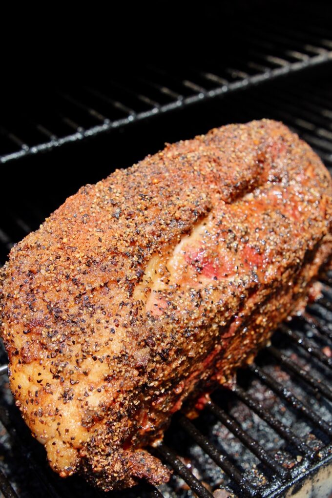 seasoned pork shoulder on a smoker