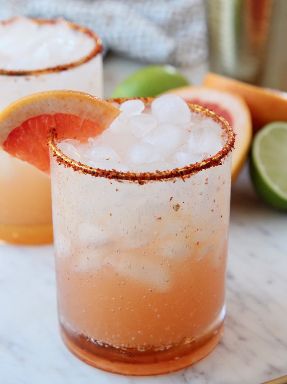 paloma in glass with tajin on the rim and grapefruit wedge on the edge of the glass