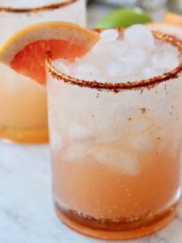 paloma in glass with tajin on the rim and grapefruit wedge on the edge of the glass