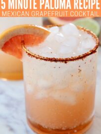 paloma in glass with ice and tajin rim on the glass with a grapefruit wedge