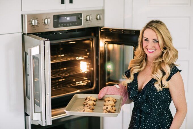 woman holding cookies coming out of the oven