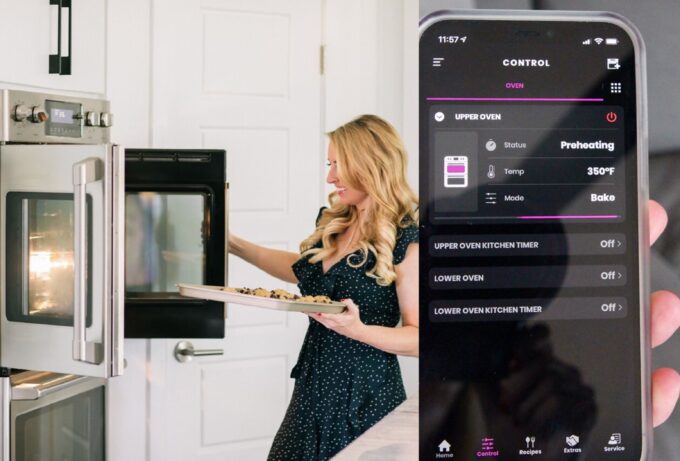 woman opening door of oven and phone with smart oven app showing