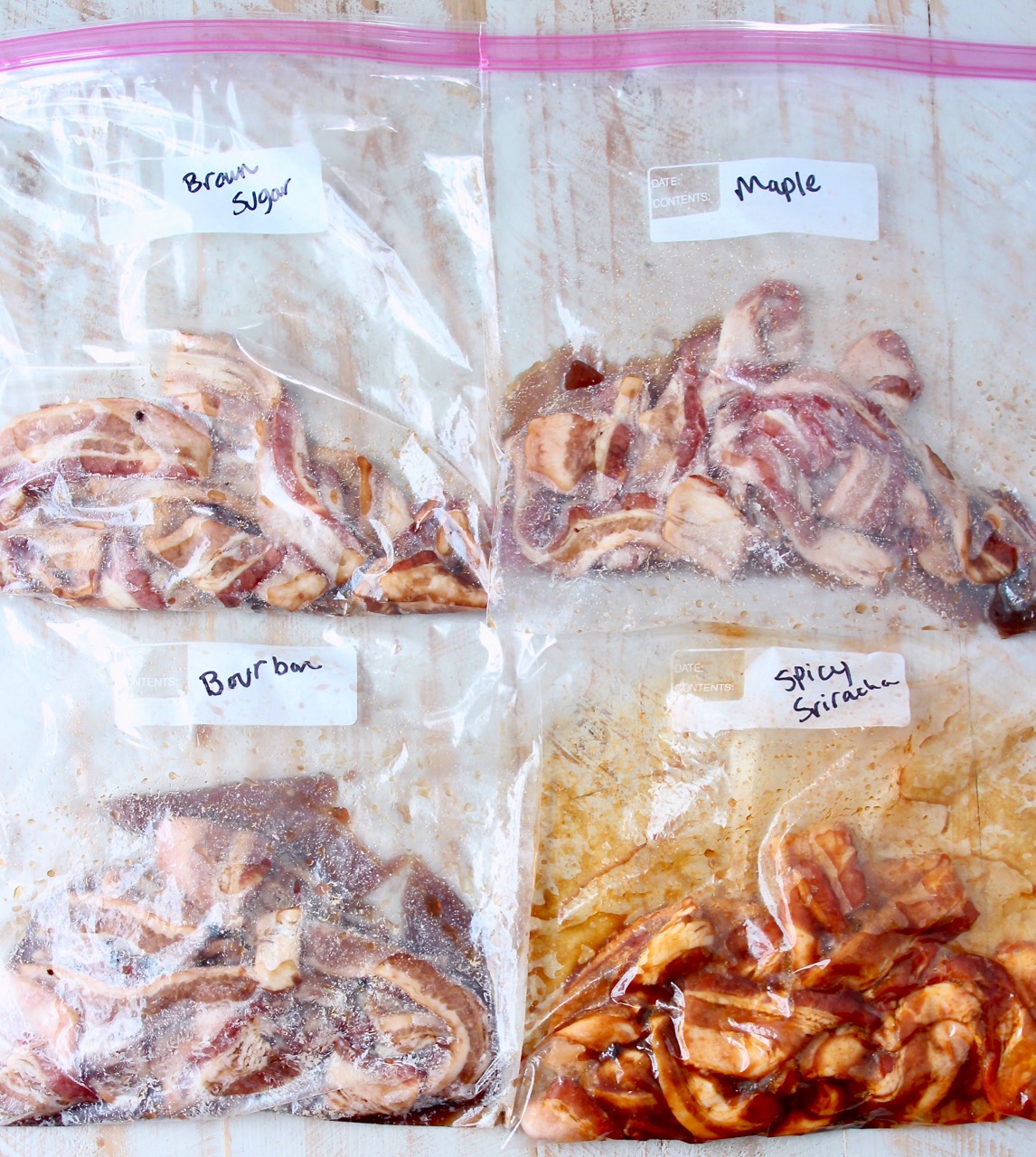 uncooked bacon in large zipper bags with sauce, sugar and seasonings