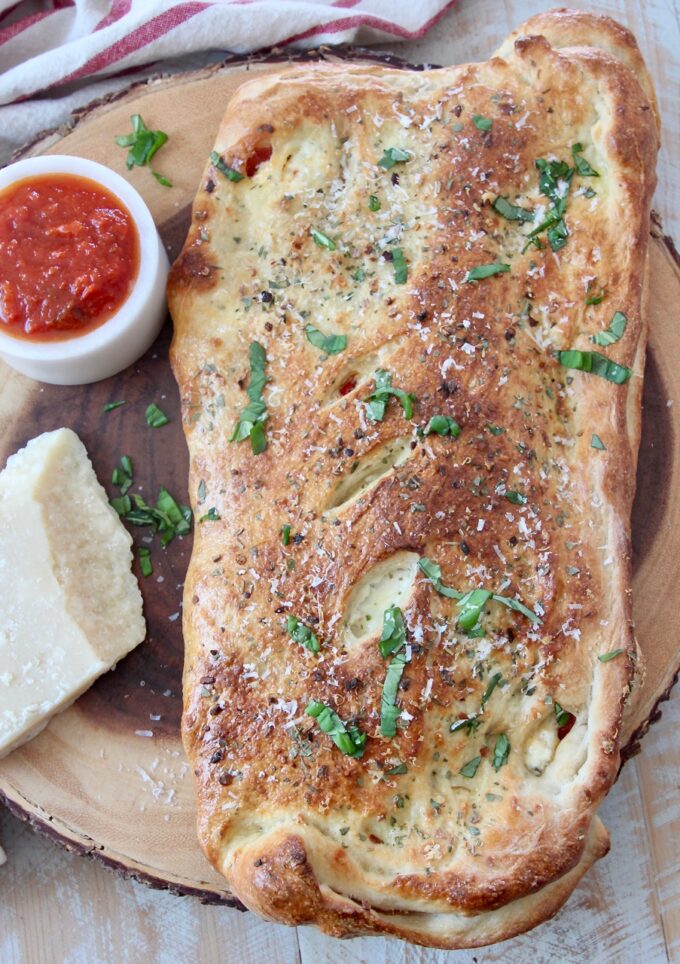 baked calzone on wood serving board