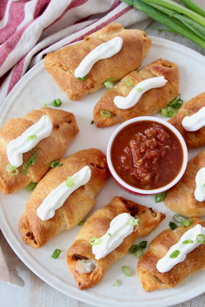 baked taco croissants on plate topped with sour cream