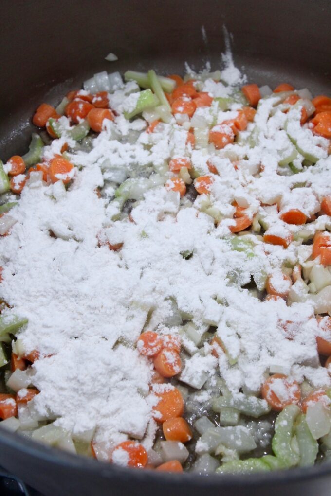 flour sprinkled over diced vegetables in a large pot