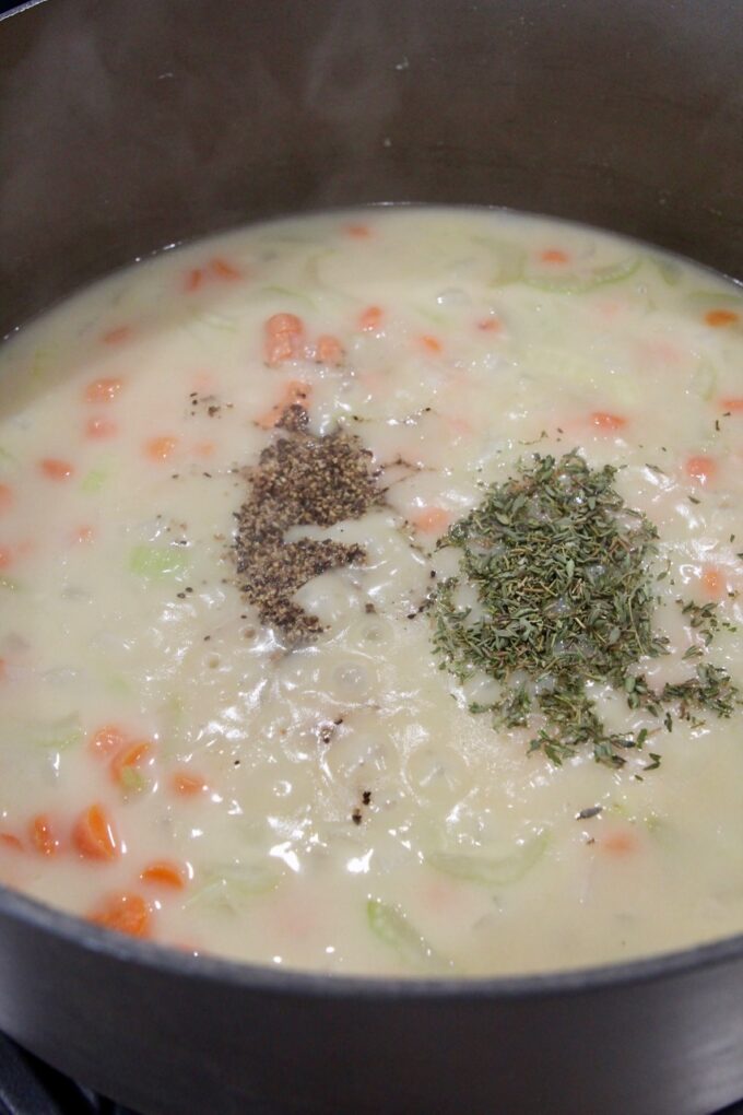 creamy mixture of vegetables in a pot topped with herbs and spices