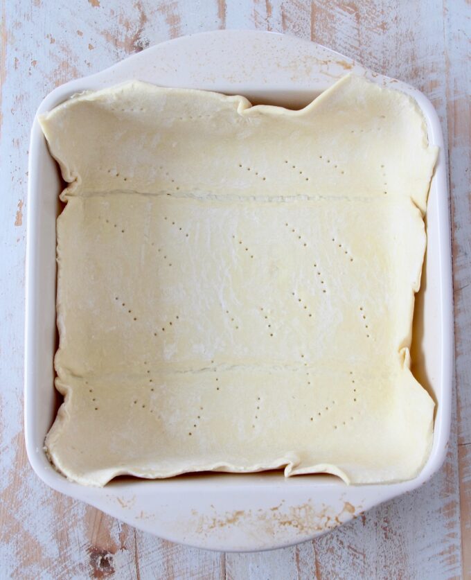 puff pastry dough pressed into a square baking dish