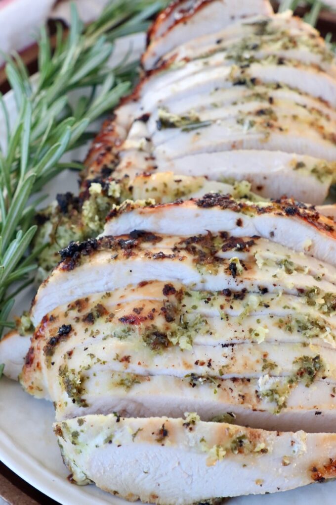 sliced turkey on plate with fresh rosemary