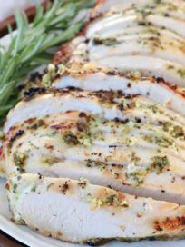 sliced turkey breast on plate with fresh rosemary