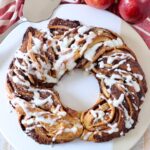 baked cinnamon roll wreath drizzled with cream cheese frosting